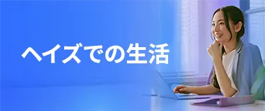 デスクでノートパソコンを前に微笑む若い女性、ヘイズでの働く環境を示すイメージ