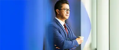 Business executive in blue suit looking out window – Hays Japan recruitment outsourcing solutions.