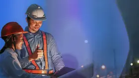 Engineers reviewing blueprints at a construction site