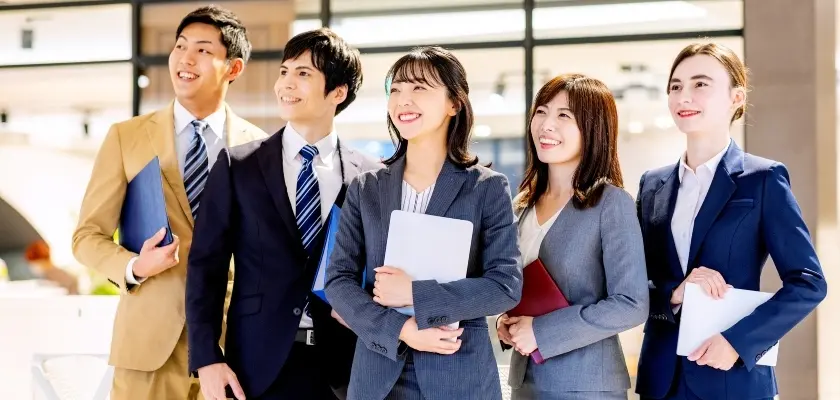 スーツ姿で笑顔を見せる若手ビジネスパーソンのグループ