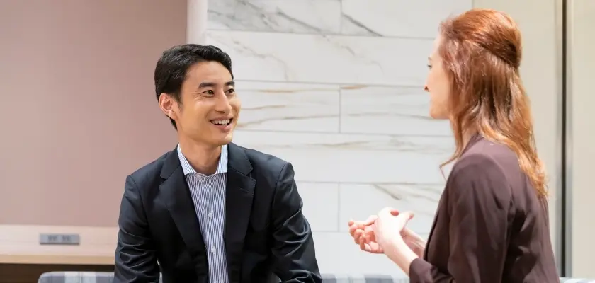 日本人男性と外国人女性が会話するビジネスシーン