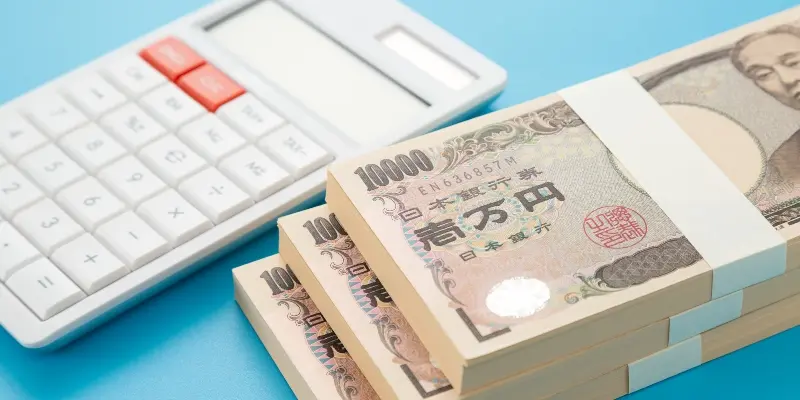電卓と一万円札の札束、日本円のイメージ