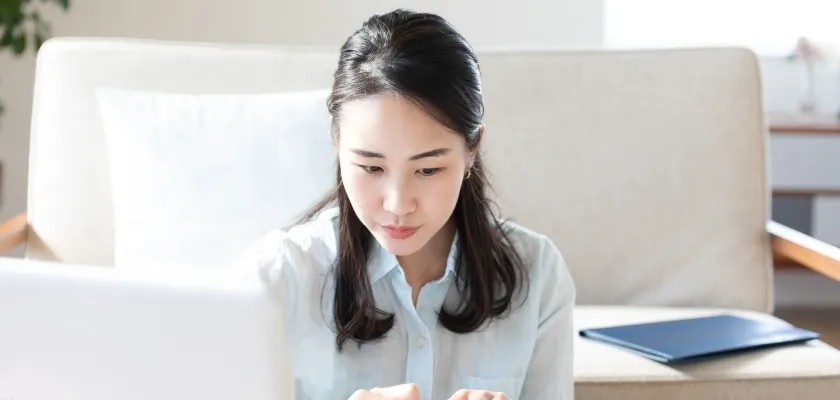 自宅でノートパソコンに集中する女性
