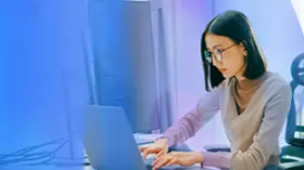 Technology specialist working on a laptop in a modern office 